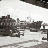 1950-BR-87-Blick-von-der-Laderampe-auf-Schuten-die-hoch-mit-Baumstammen-tropischer-Holzer-beladen-sind